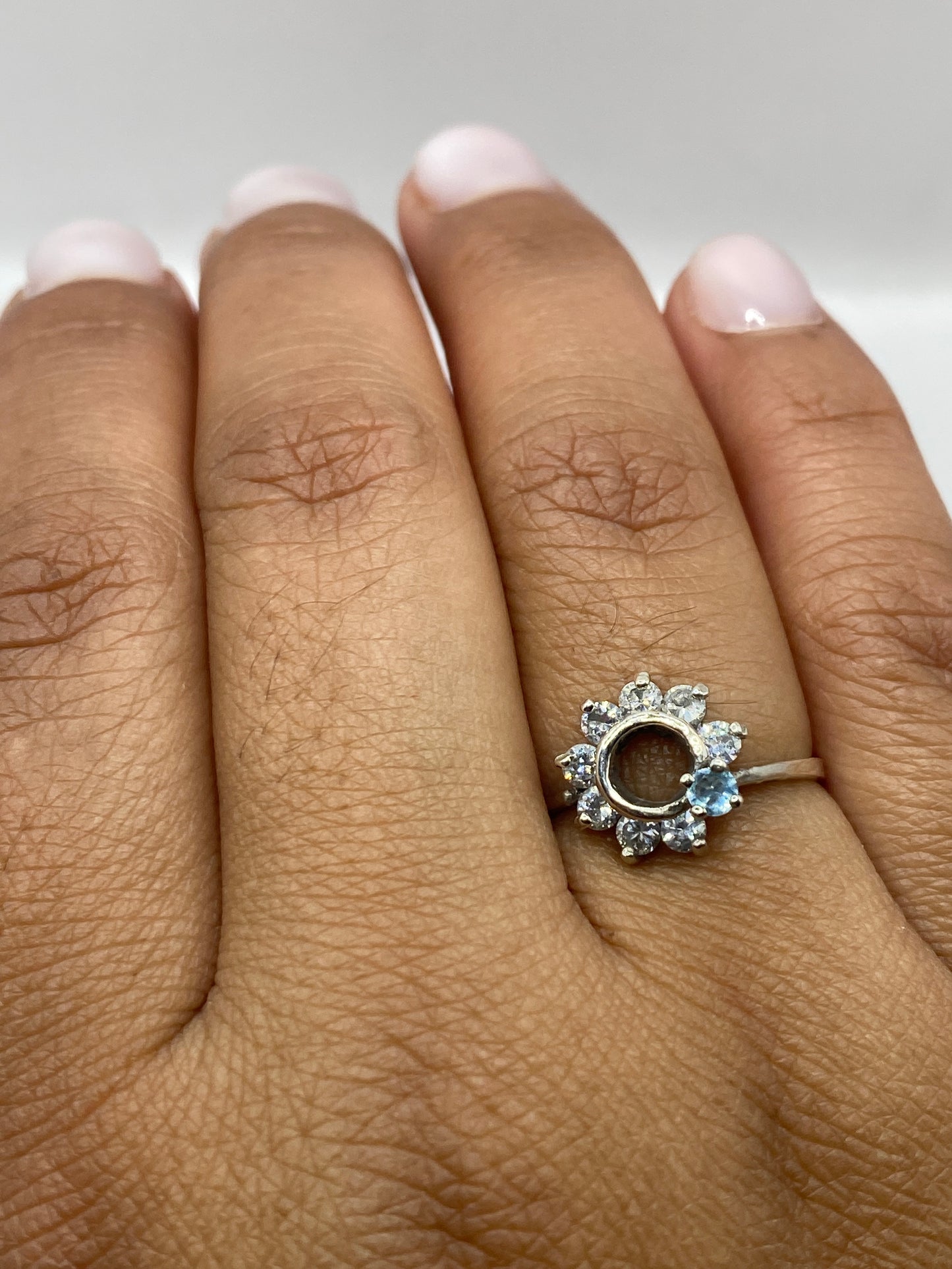 Anillo solitario en fondo gris mostrando el sello 925 y el pulido impecable