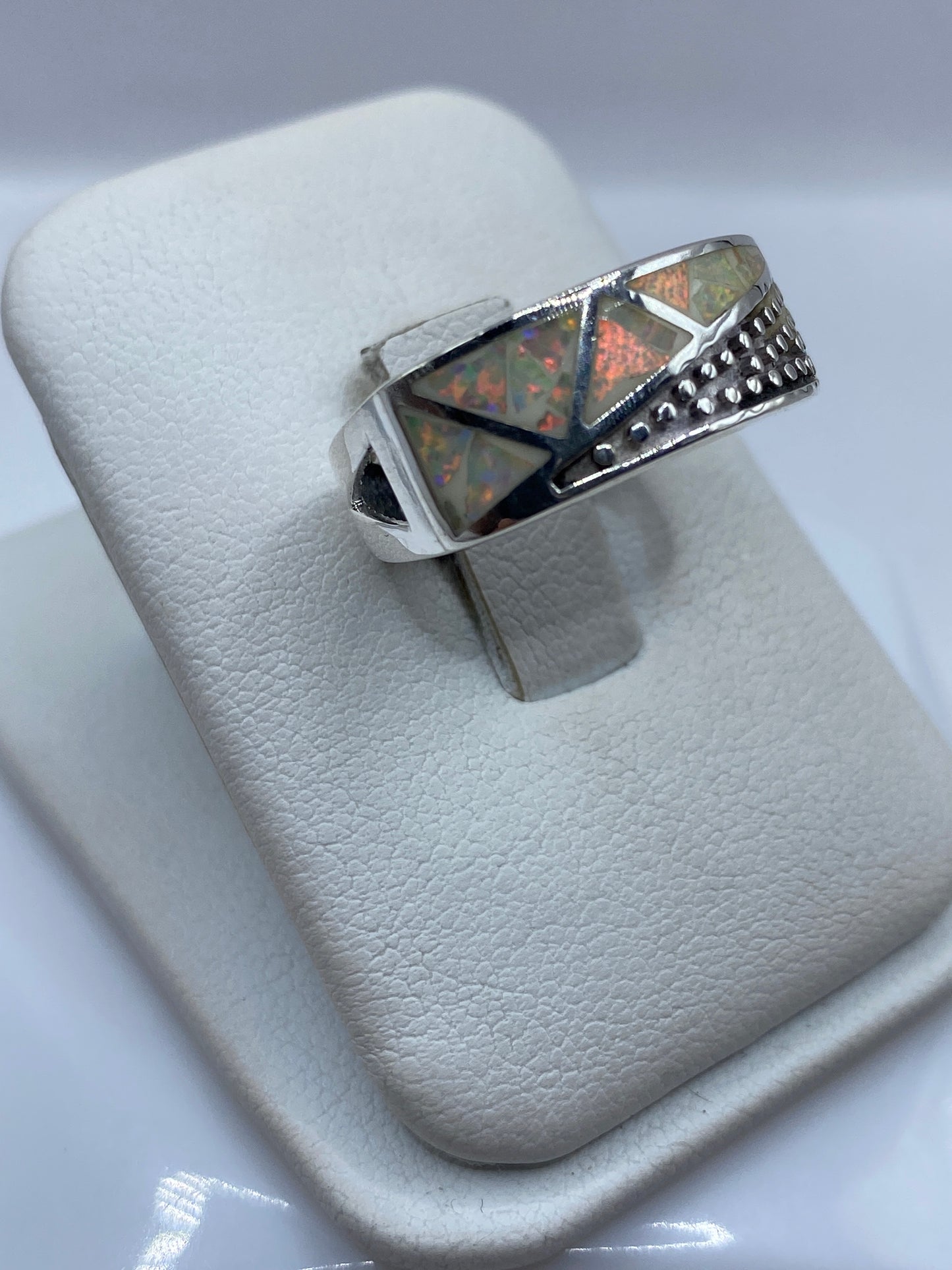 Vista frontal del anillo unisex geométrico con piedra de fuego en posición vertical