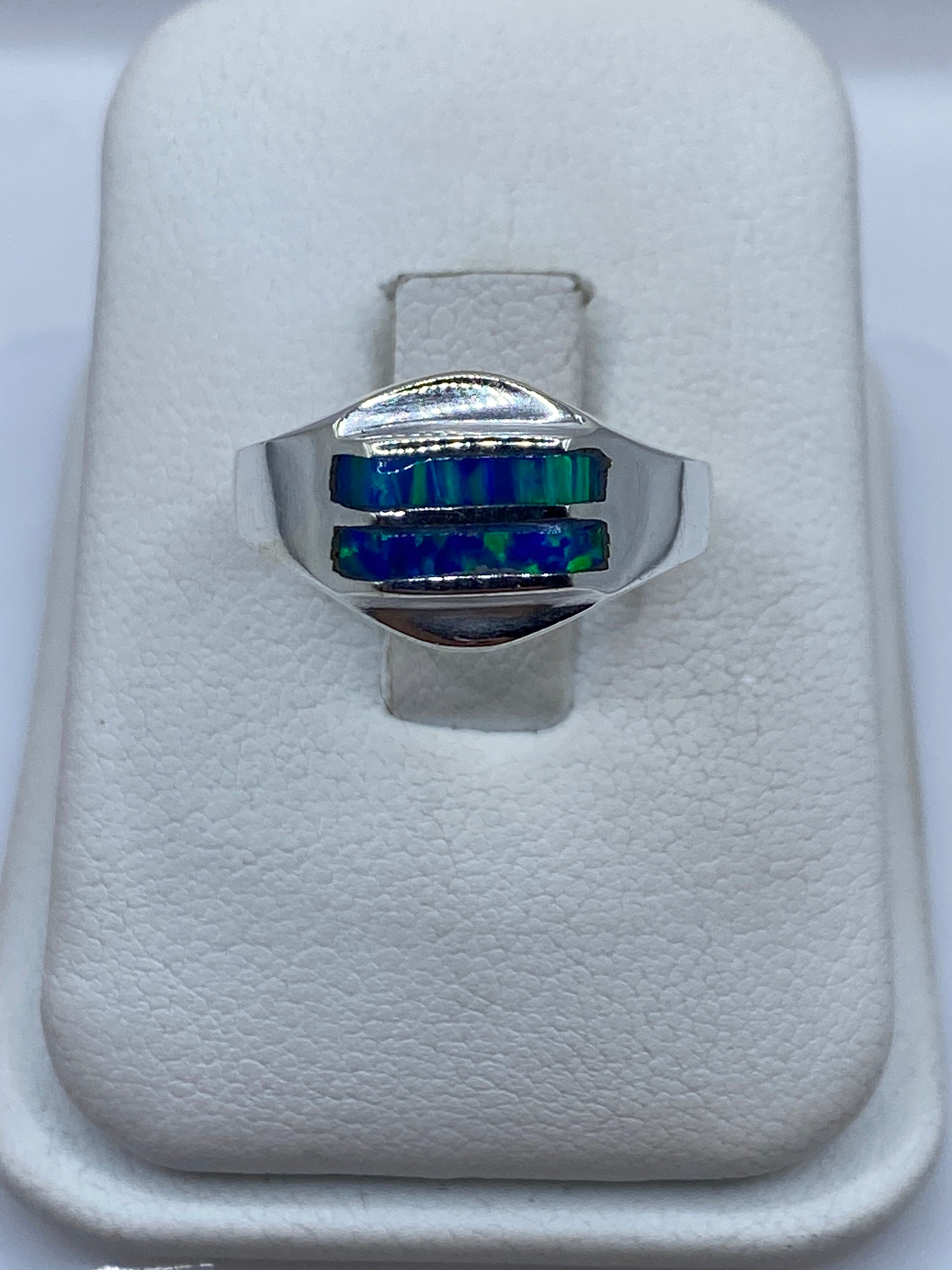 Anillo de plata con ópalo de fuego azul en la mano de una mujer