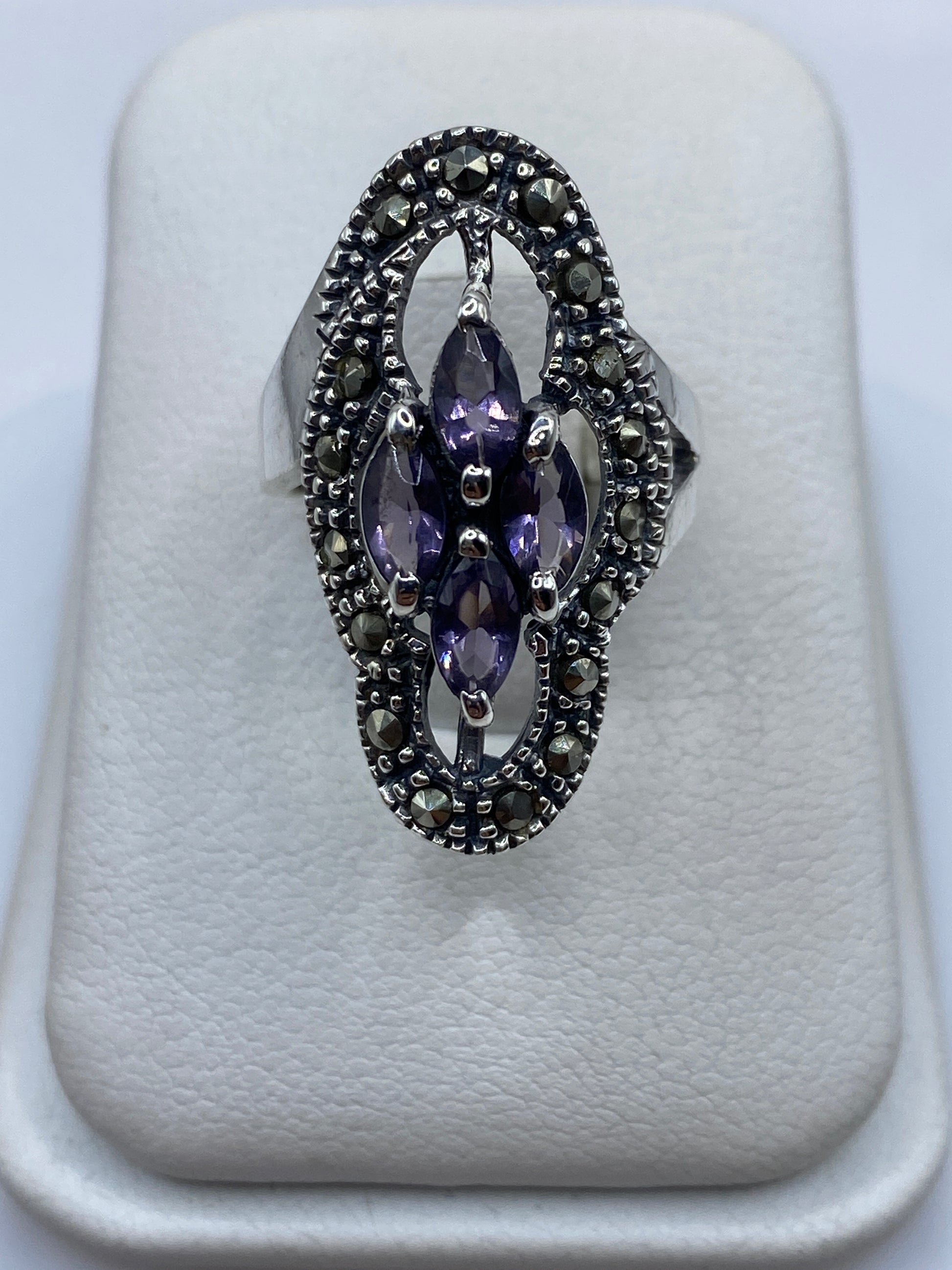 Anillo vintage de plata .925 con circonia morada facetada, sostén en mano femenina