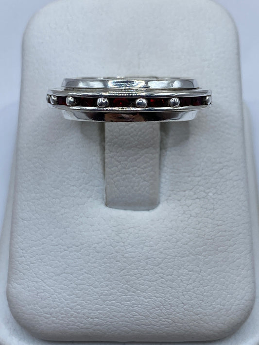 Anillo de plata con circonia roja tipo rubí en caja de presentación blanca, vista superior