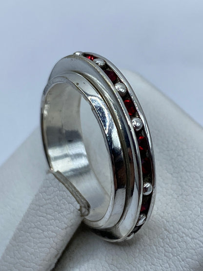 Anillo de plata .925 en dedo, con circonia roja brillante bajo luz natural