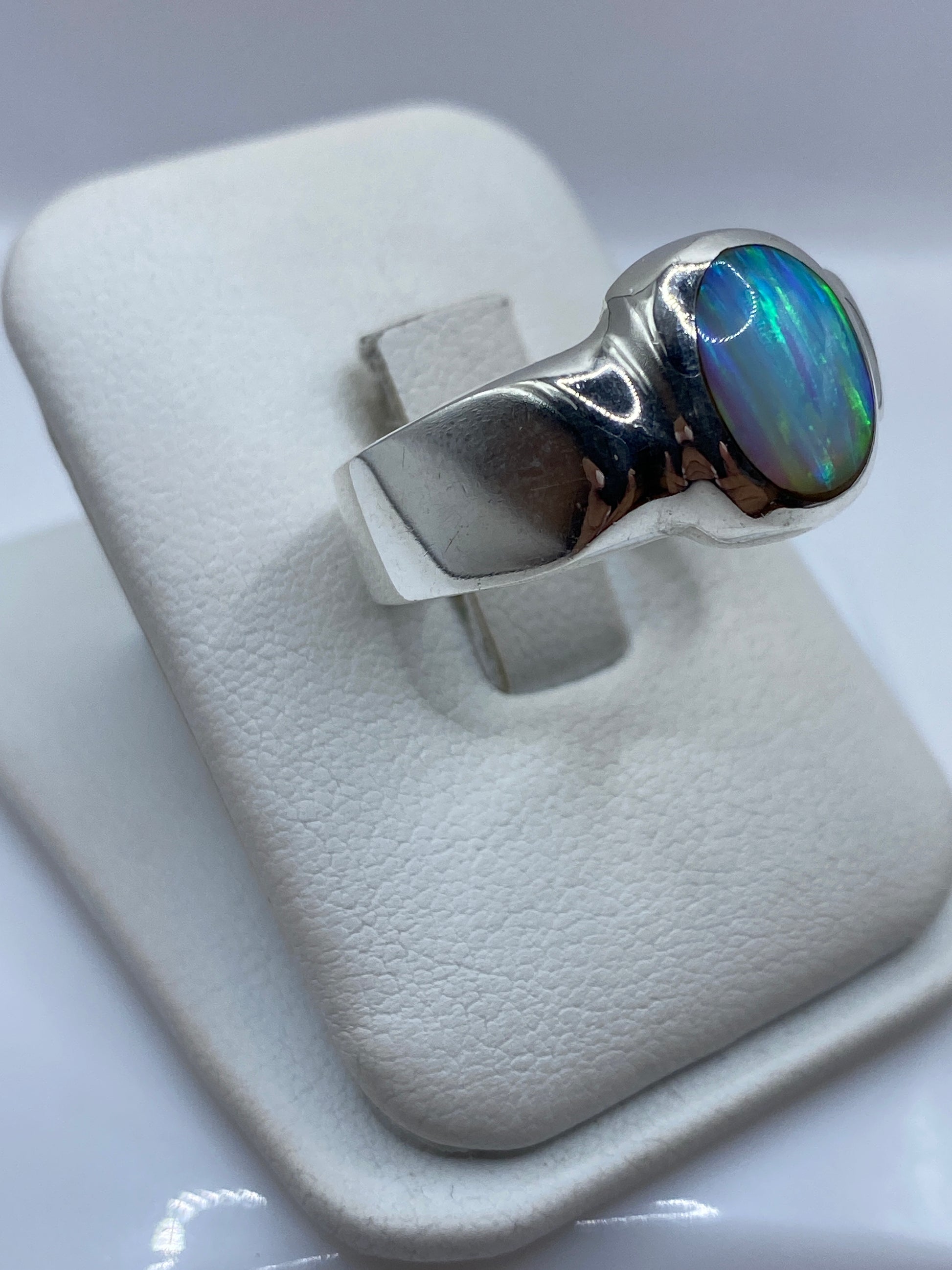 Vista lateral del anillo ópalo de fuego en plata .925 mostrando el engaste bezel