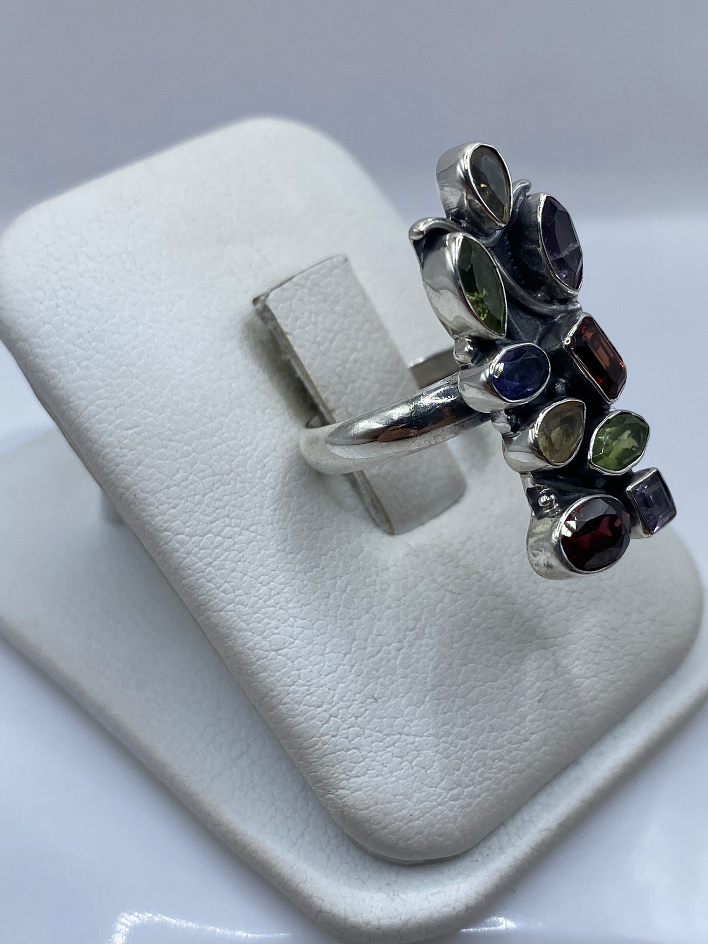Vista lateral del anillo de plata .925 con circonias azul, verde, amarillo, granate y lila