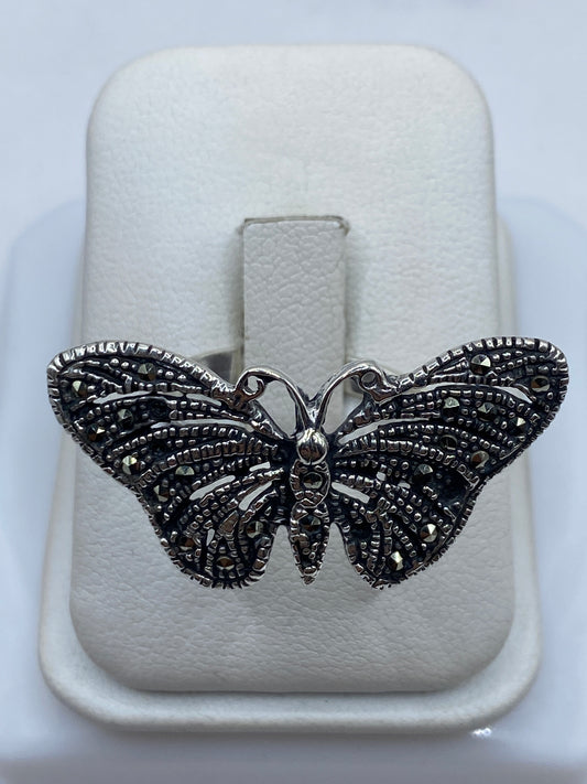 Anillo mariposa de plata .925 con filigrana detallada en la mano de una mujer