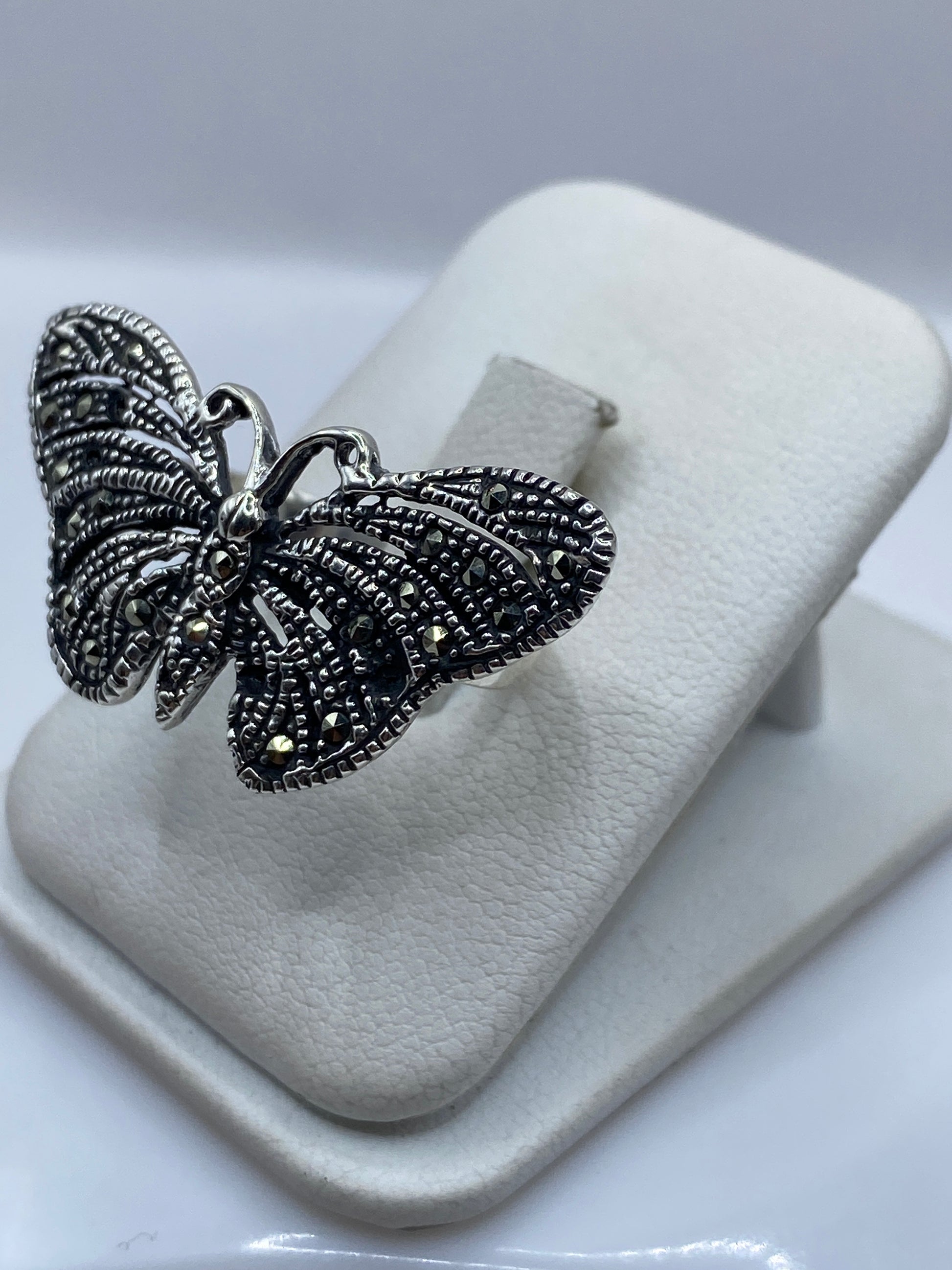 Vista frontal del anillo mariposa artesanal mostrando las alas labradas en Taxco