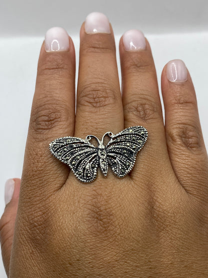 Anillo mariposa sobre fondo plateado mostrando el sello 925 auténtico