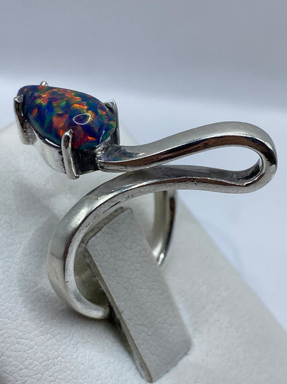 Anillo orgánico de plata sobre dedo, luciendo el fuego del ópalo