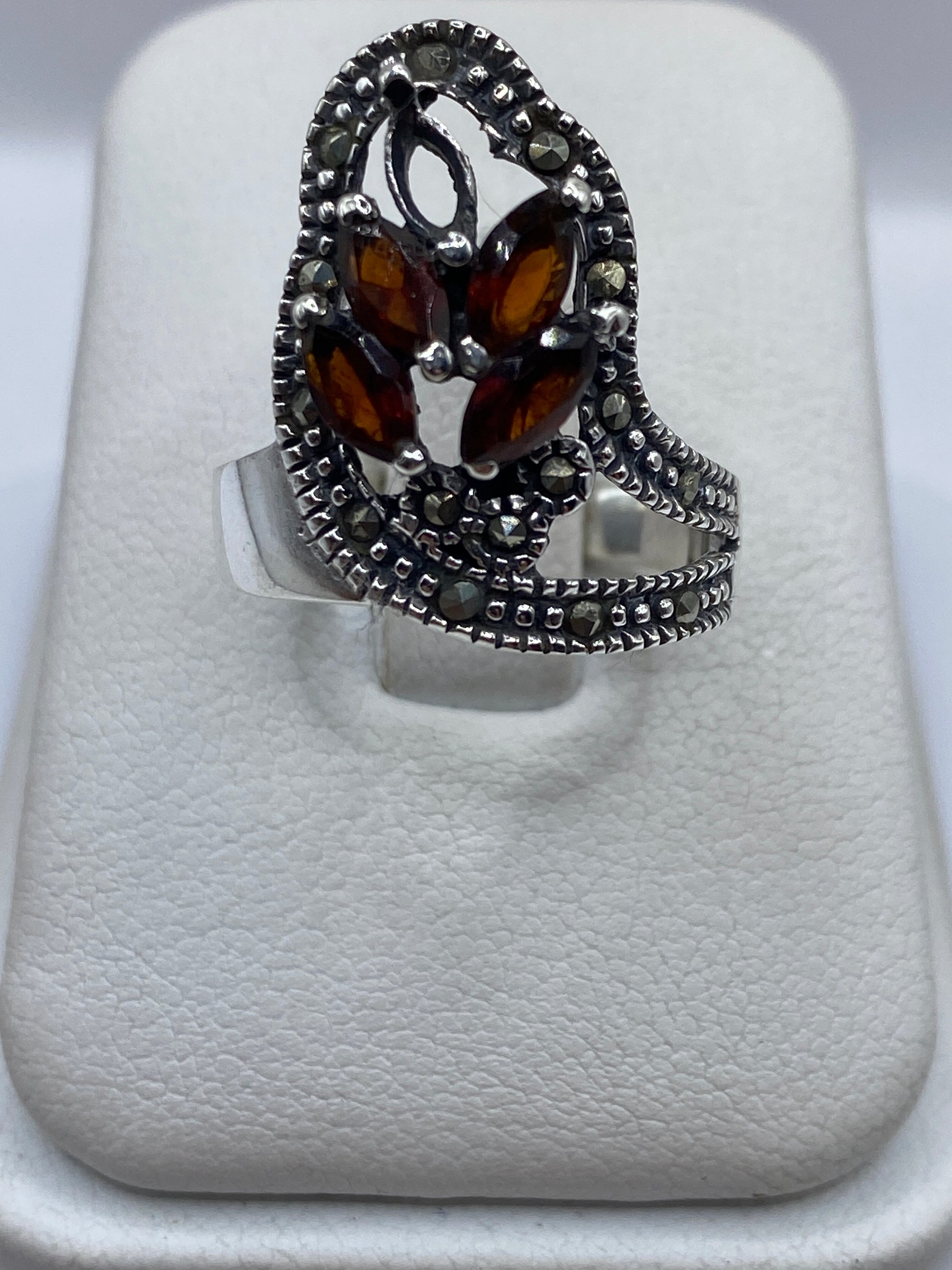 Anillo de plata texturizado con circonia café en la mano de una mujer