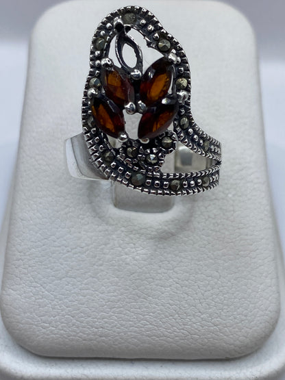 Anillo de plata texturizado con circonia café en la mano de una mujer