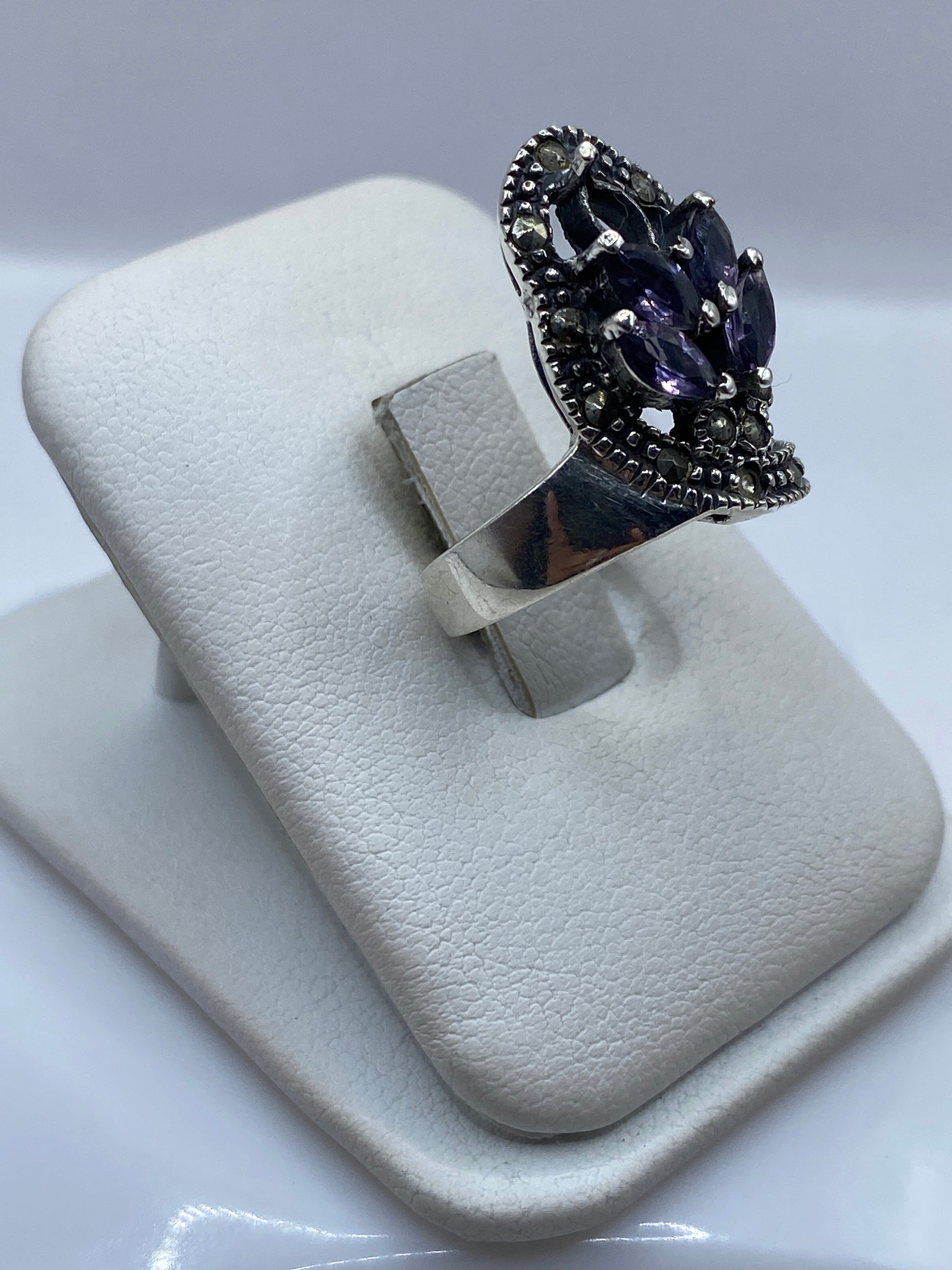 Vista frontal del anillo elegante con frente de circonia morada y banda de plata .925