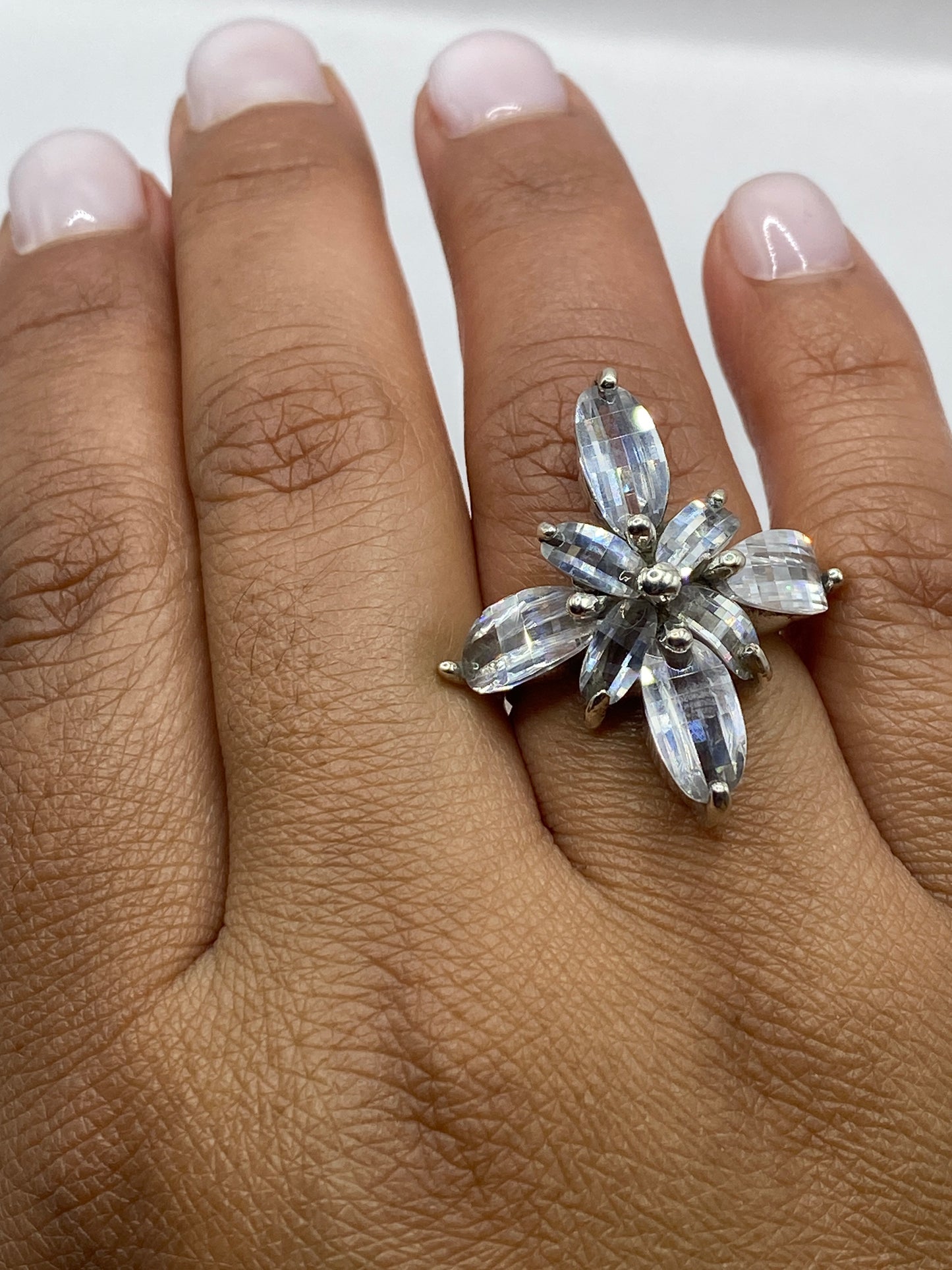 Anillo sobre fondo gris mostrando el sello .925 y el brillo de la piedra