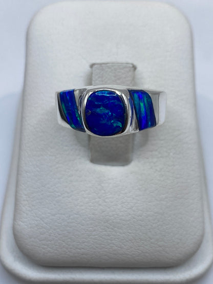 Anillo de plata .950 con ópalo de fuego azul en estuche blanco sobre la mano