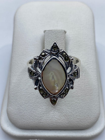 Anillo de plata vintage con piedra natural sobre dedo de mujer, mostrando detalle ornamental
