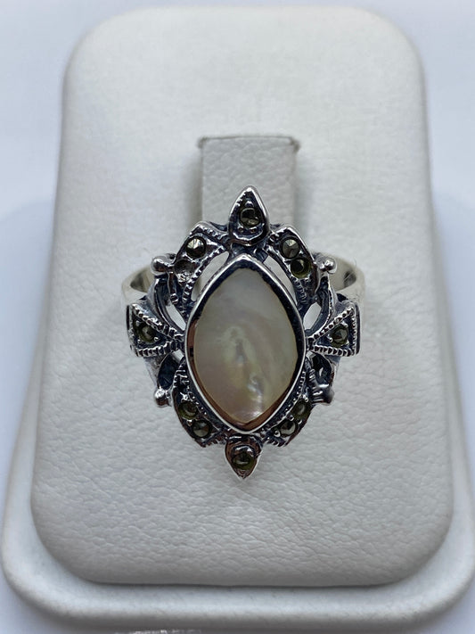 Anillo de plata vintage con piedra natural sobre dedo de mujer, mostrando detalle ornamental
