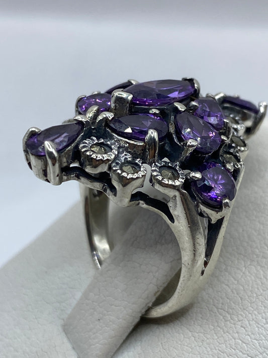 Anillo coctel de plata con circonias púrpuras facetadas en la mano de una mujer