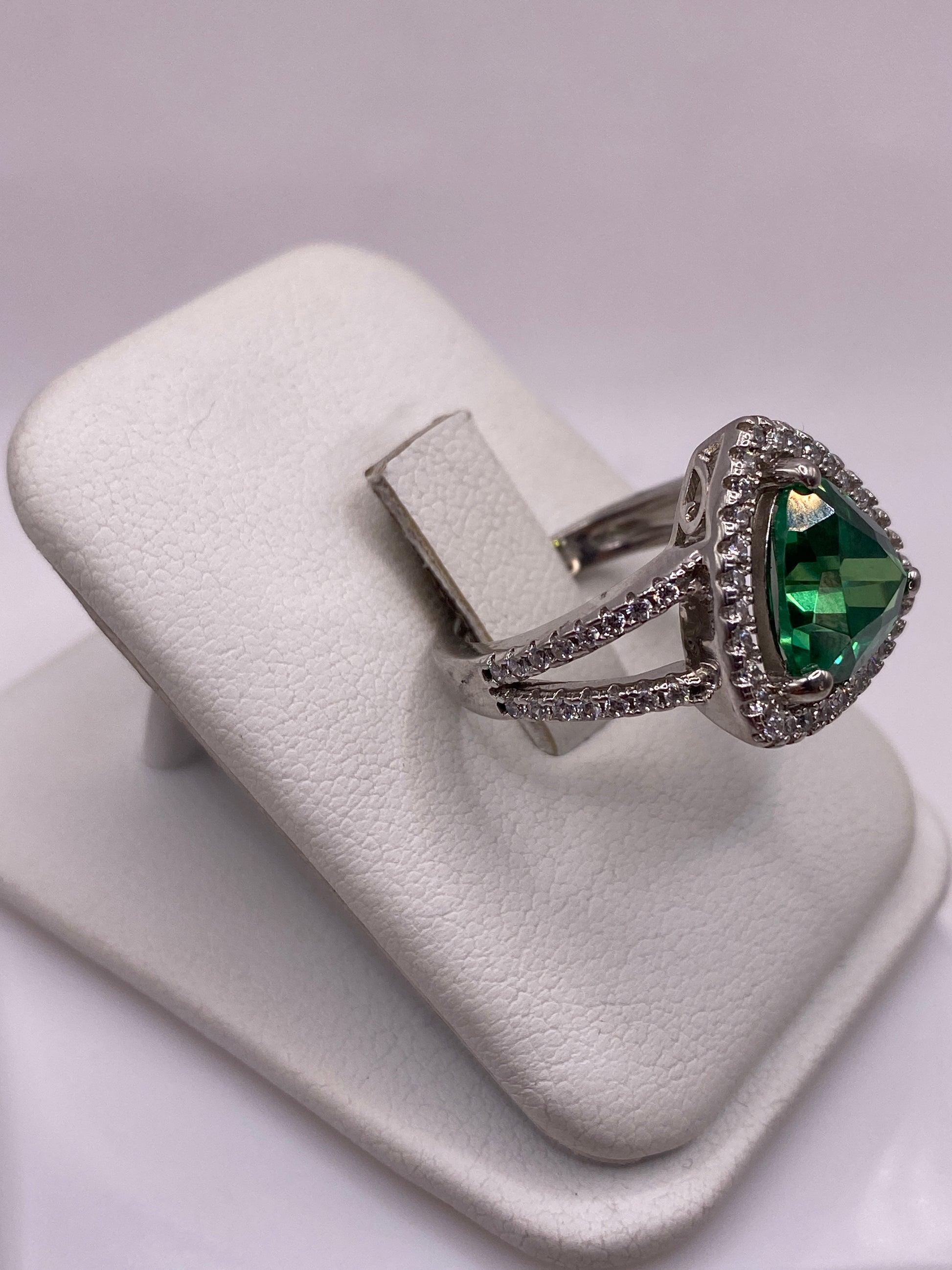 Detalle lateral del anillo solitario mostrando el engaste de la circonia verde en plata pura