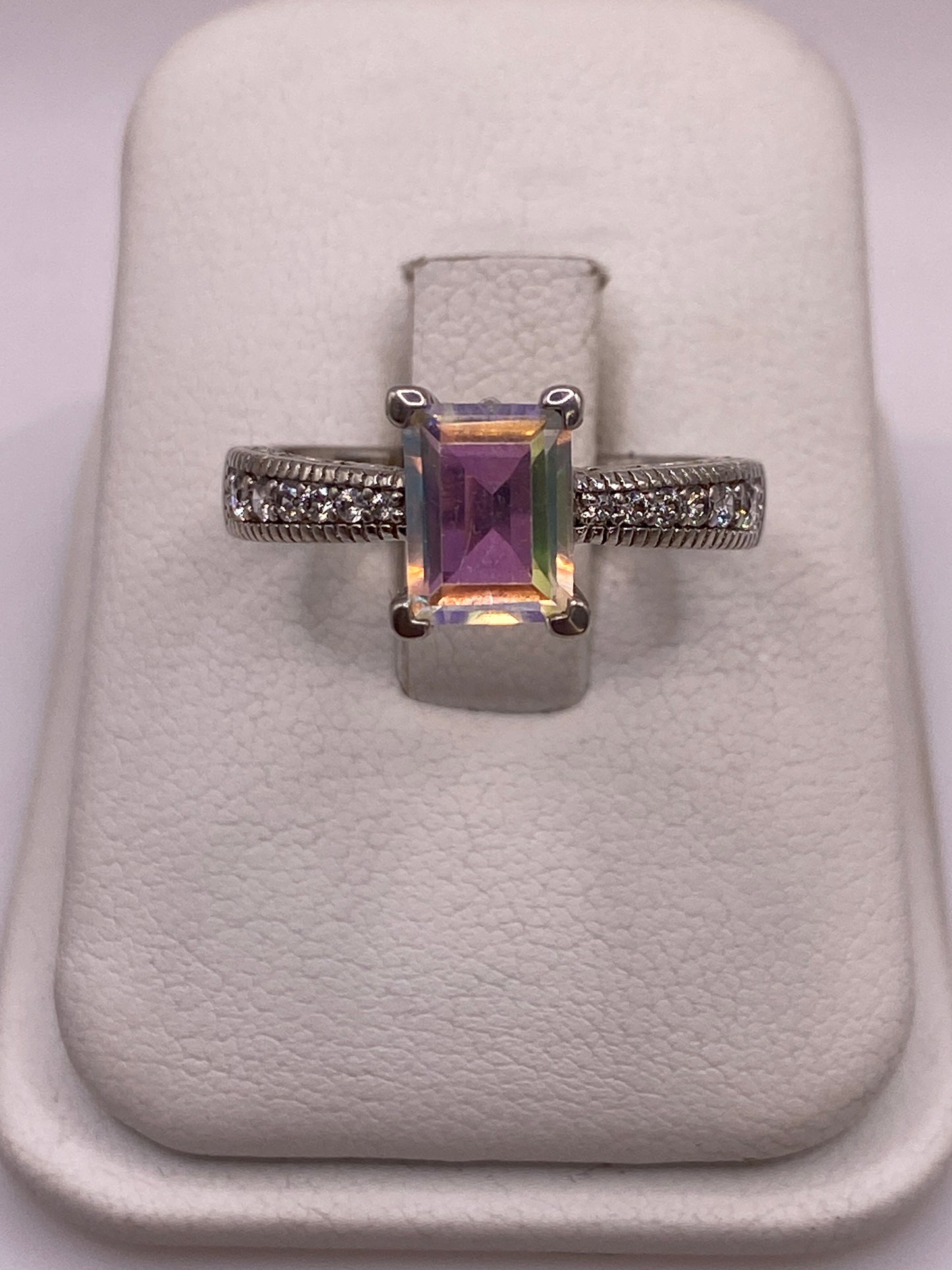 Anillo de plata solitario con circonia multicolor capturando luz azul y violeta