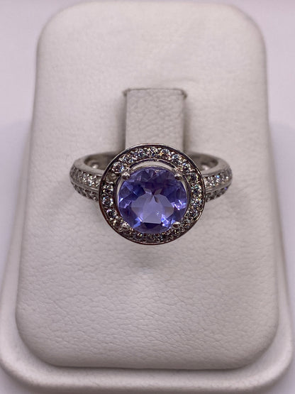 Anillo de plata solitario con circonia morada en mano de mujer con esmalte rosa
