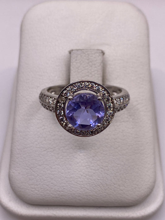 Anillo de plata solitario con circonia morada en mano de mujer con esmalte rosa
