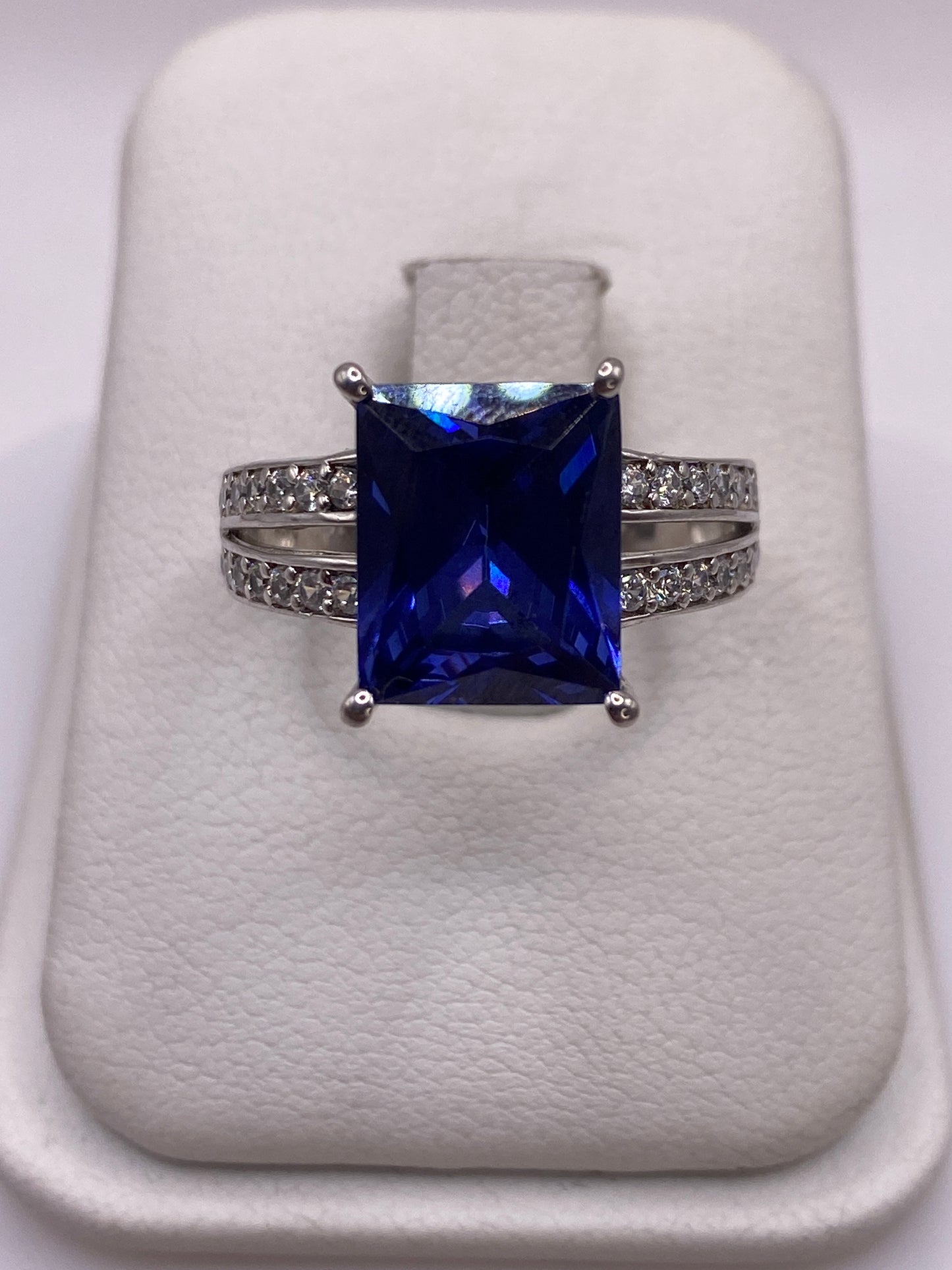 Anillo de plata solitario con circonia azul cuadrada y circonias blancas laterales
