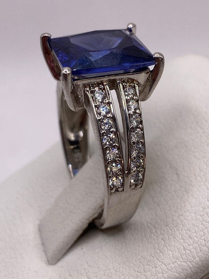 Detalle lateral del anillo con enlaces de circonias blancas flanqueando la piedra