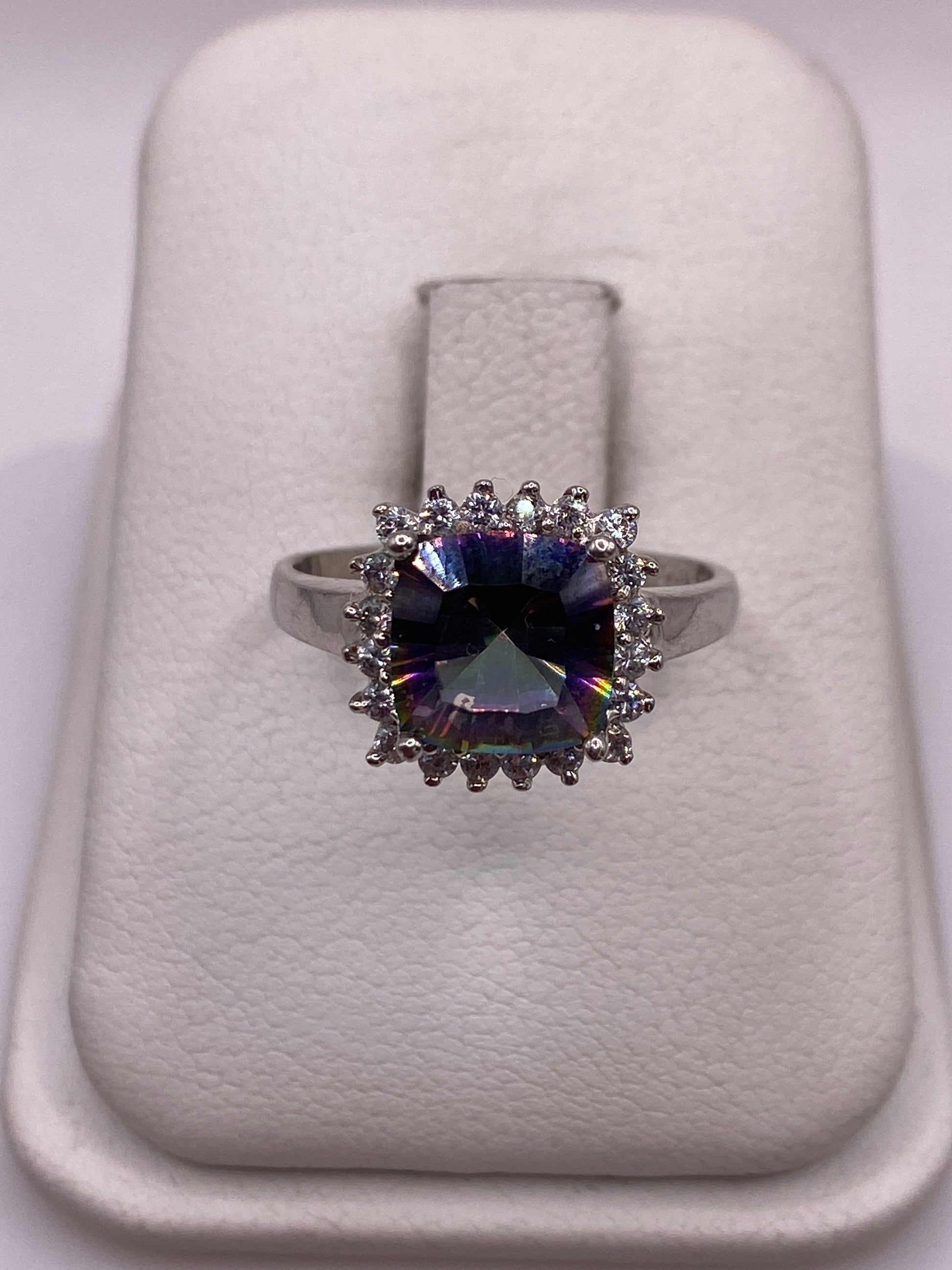 Anillo de plata con circonia multicolor solitario en la mano de una mujer