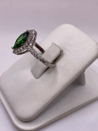 Anillo solitario verde en la mano mostrando el brillo de la piedra desde un ángulo lateral
