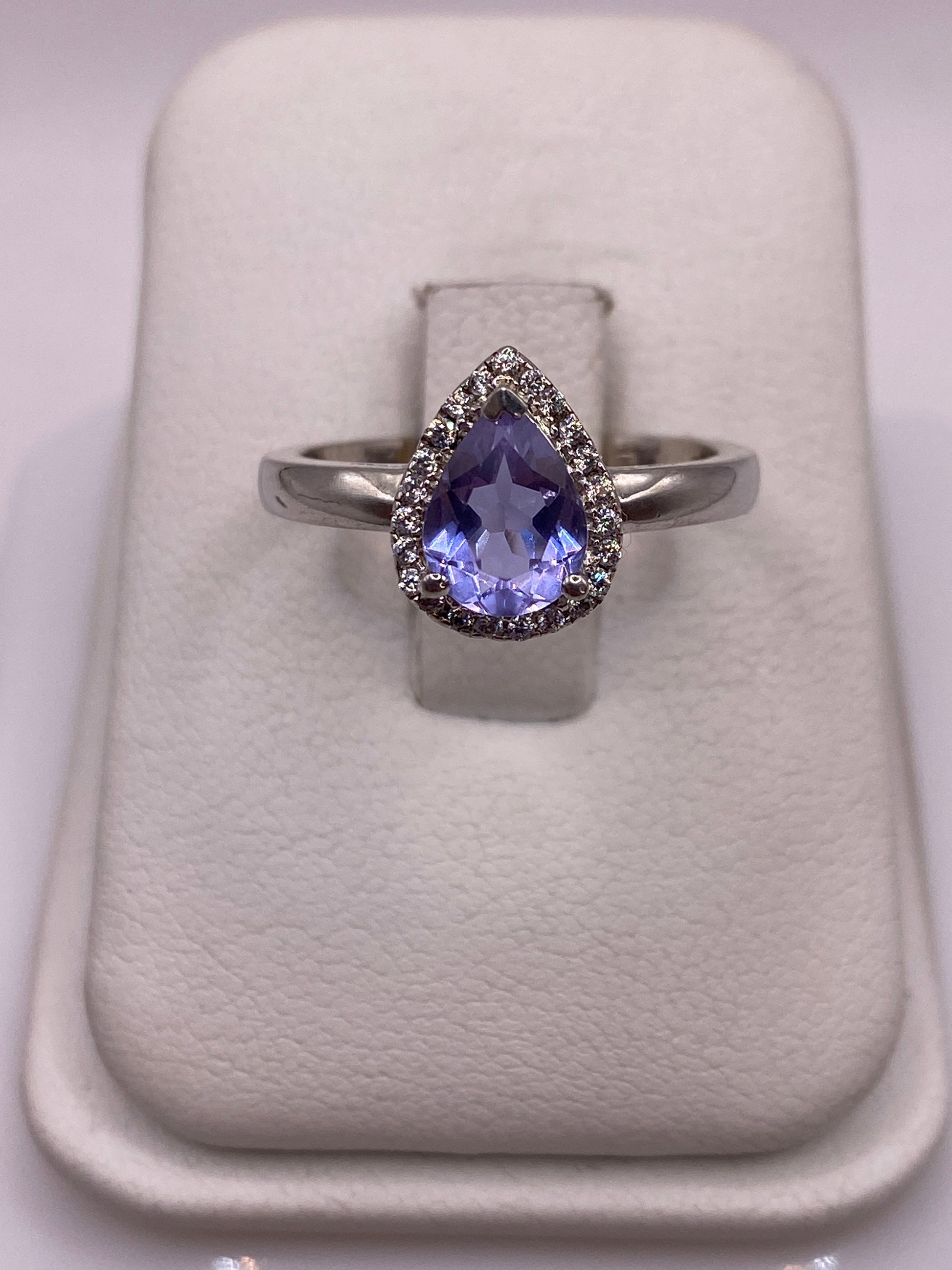 Anillo solitario de plata con circonia morada facetada en dedo de mujer