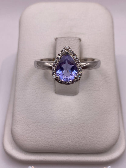 Anillo solitario de plata con circonia morada facetada en dedo de mujer