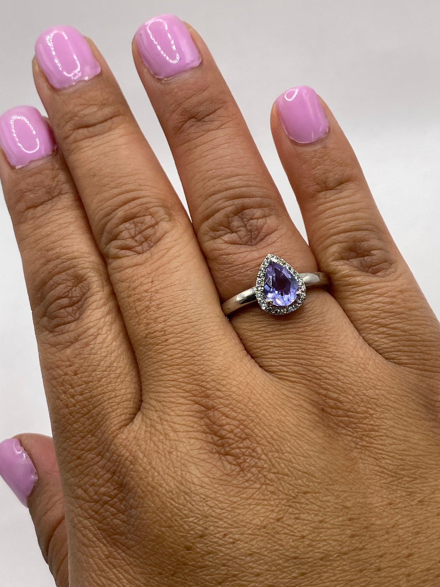 Anillo sobre fondo blanco con luz natural resaltando el brillo de la circonia morada