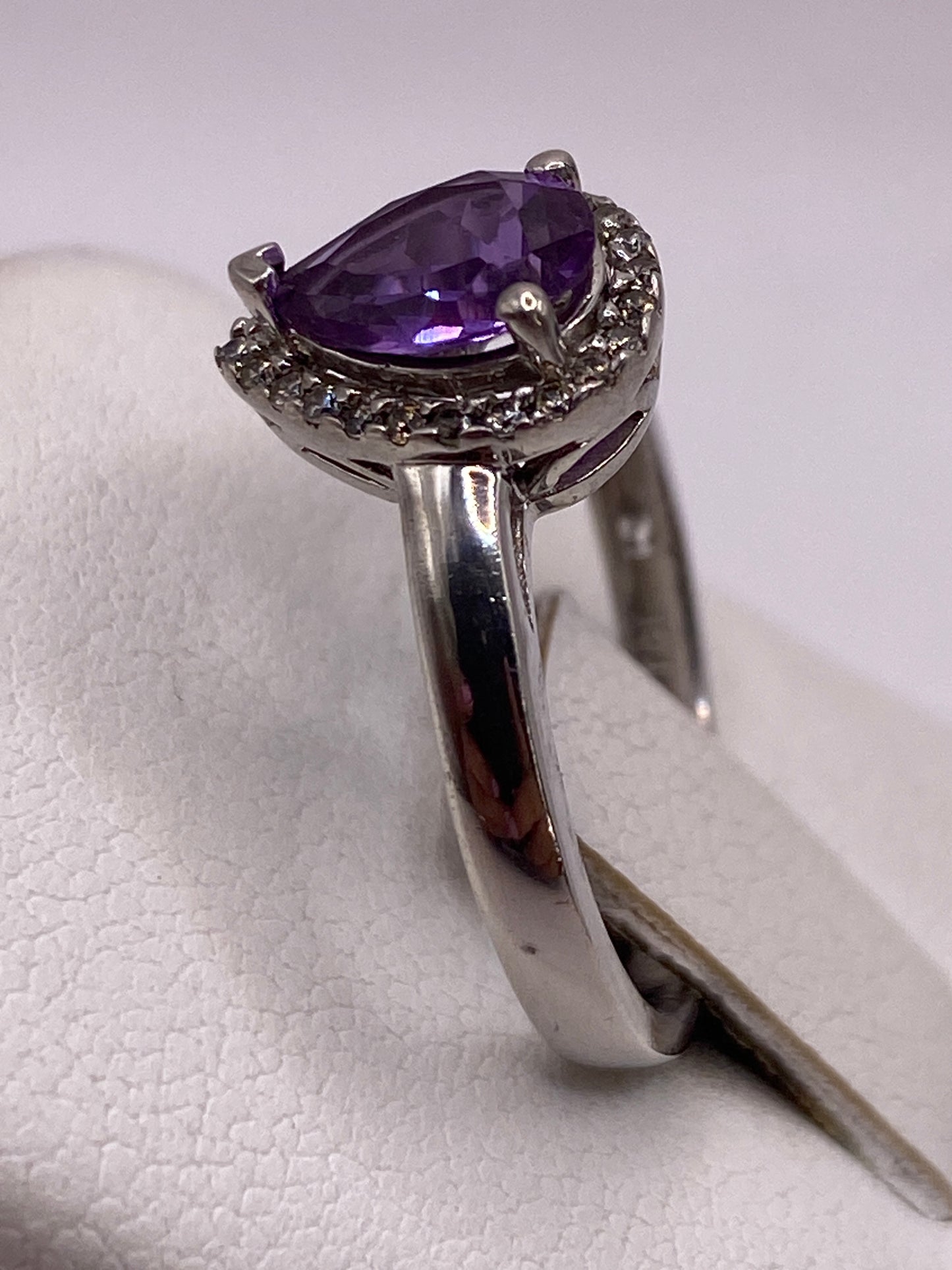 Anillo puesto en dedo mostrando el brillo de la circonia morada