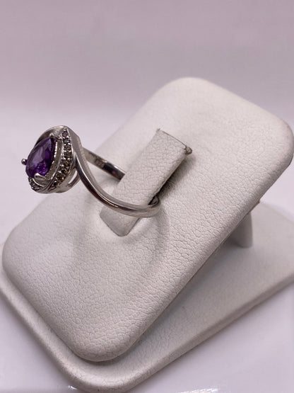 Vista de perfil del solitario de plata con piedra morada brillante