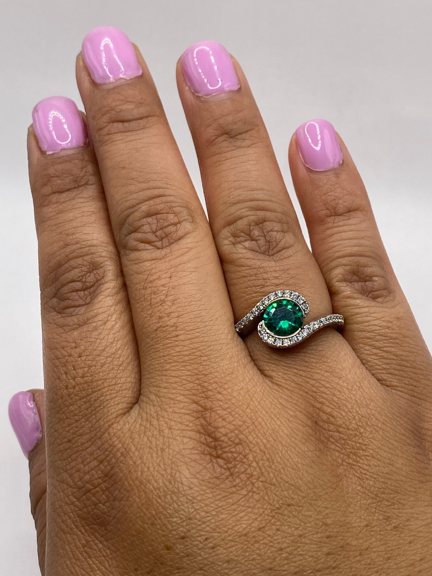 Anillo en la mano de una mujer mostrando el color verde intenso y el diseño en espiral