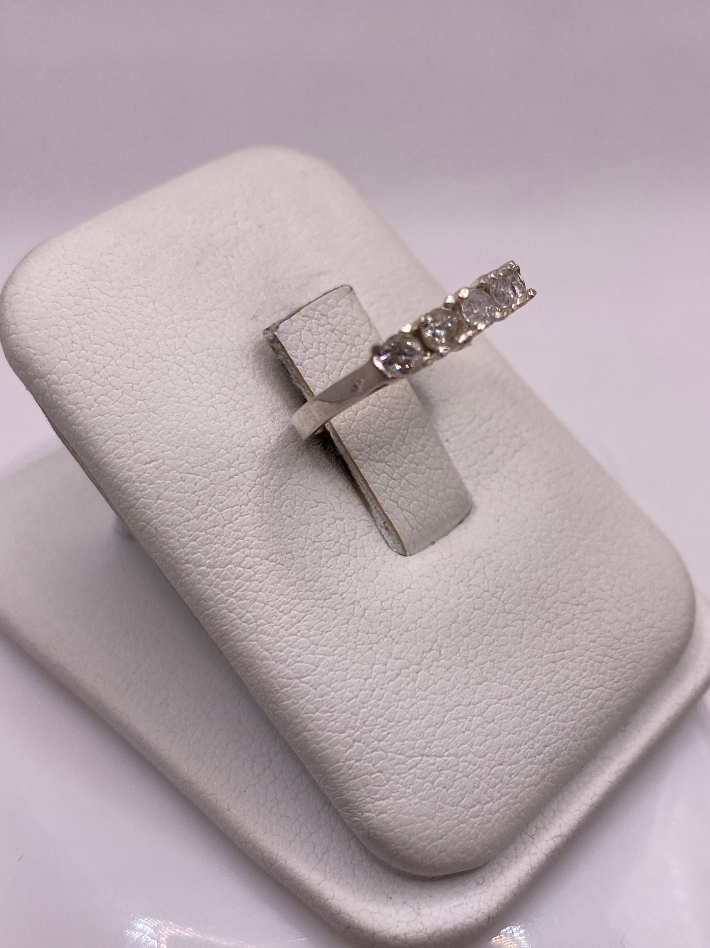 Anillo solitario circonia blanca en dedo con uñas rosa, detalle frontal