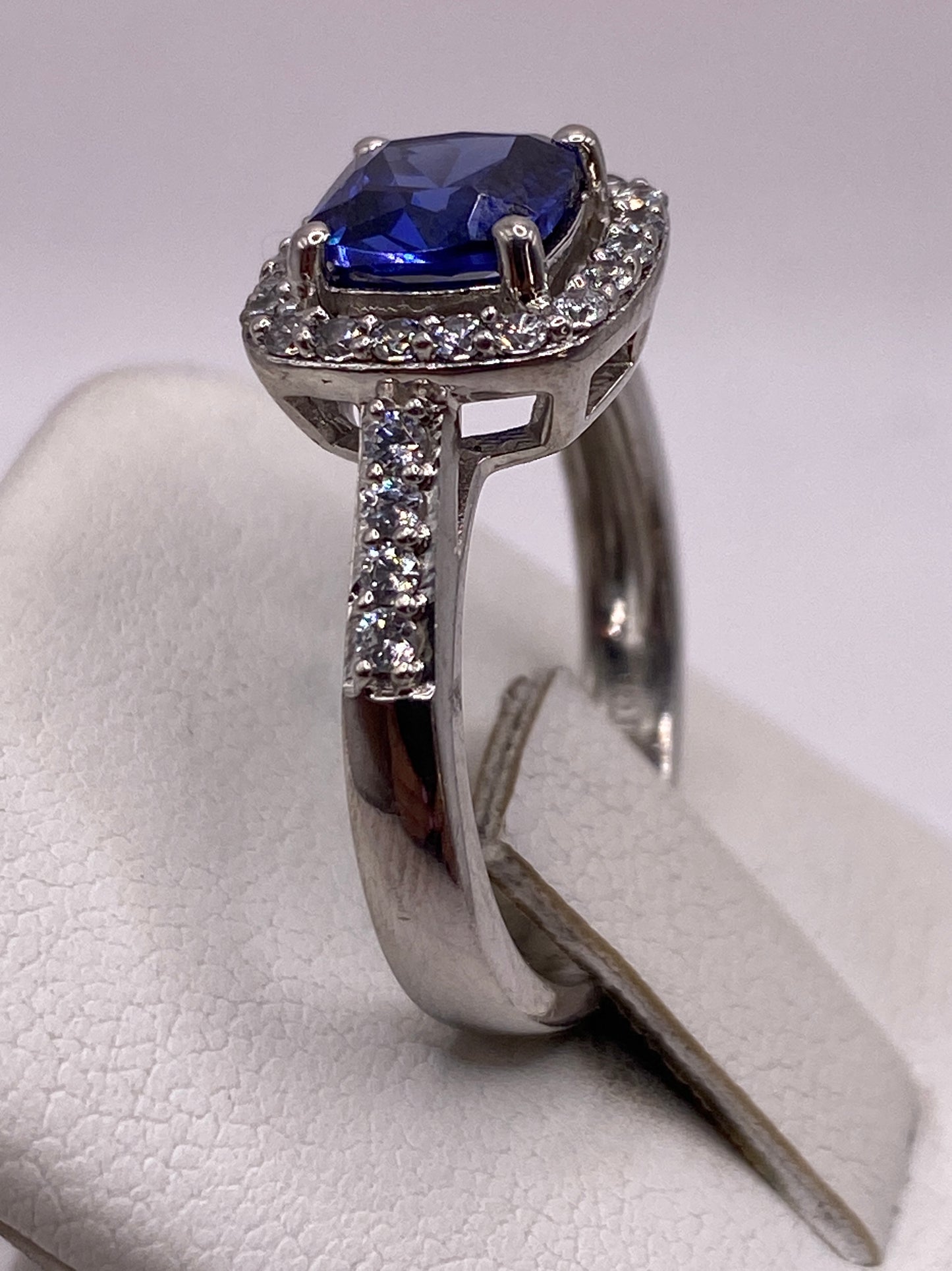 Detalle lateral del anillo solitario con marco de circonias blancas envolvente