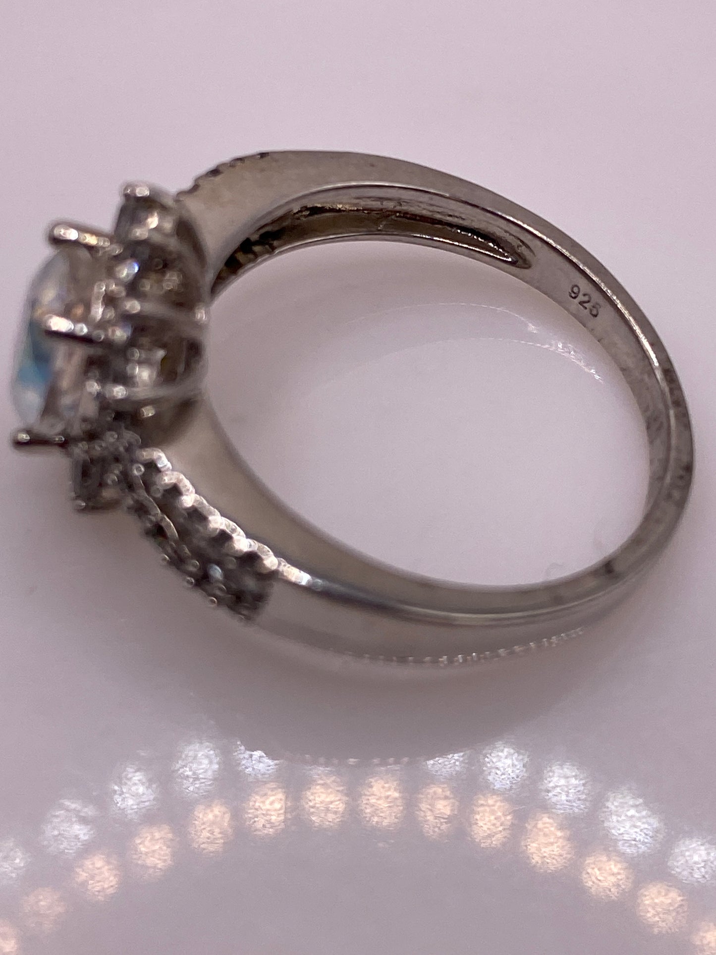 Anillo en la mano mostrando el brillo arcoíris de la circonia central y el sello .925