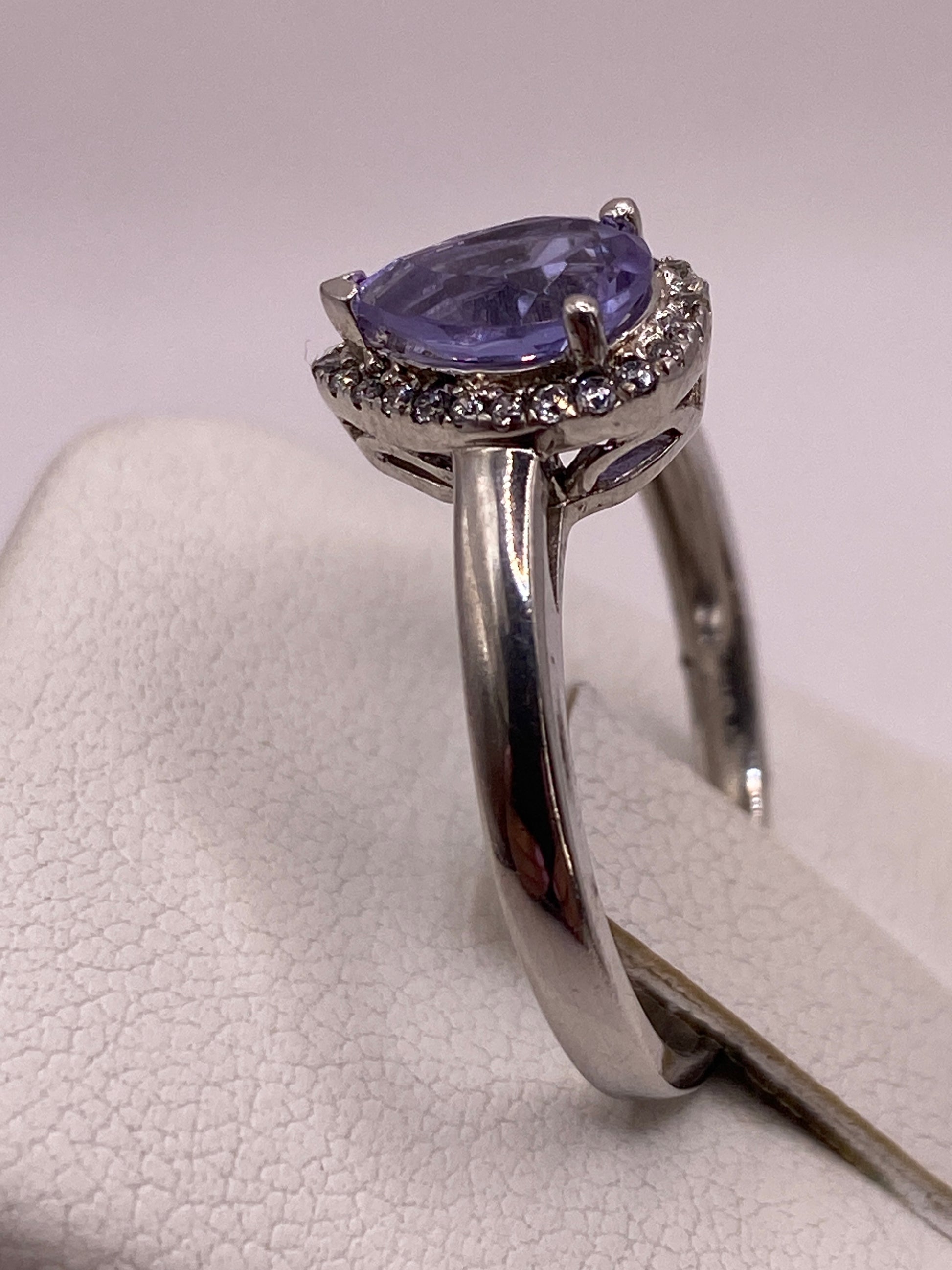 Anillo en la mano mostrando cómo brilla la circonia morada bajo luz natural