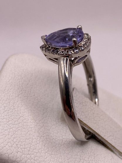 Anillo en la mano mostrando cómo brilla la circonia morada bajo luz natural