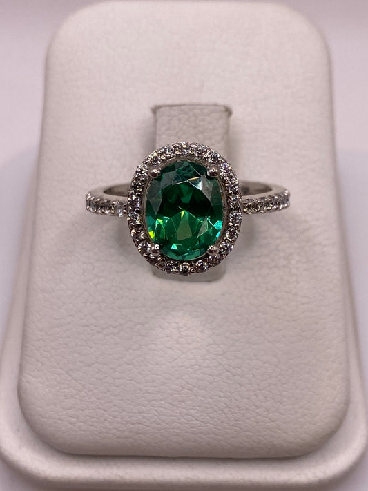 Anillo de plata solitario con circonia verde esmeralda en la mano de una mujer