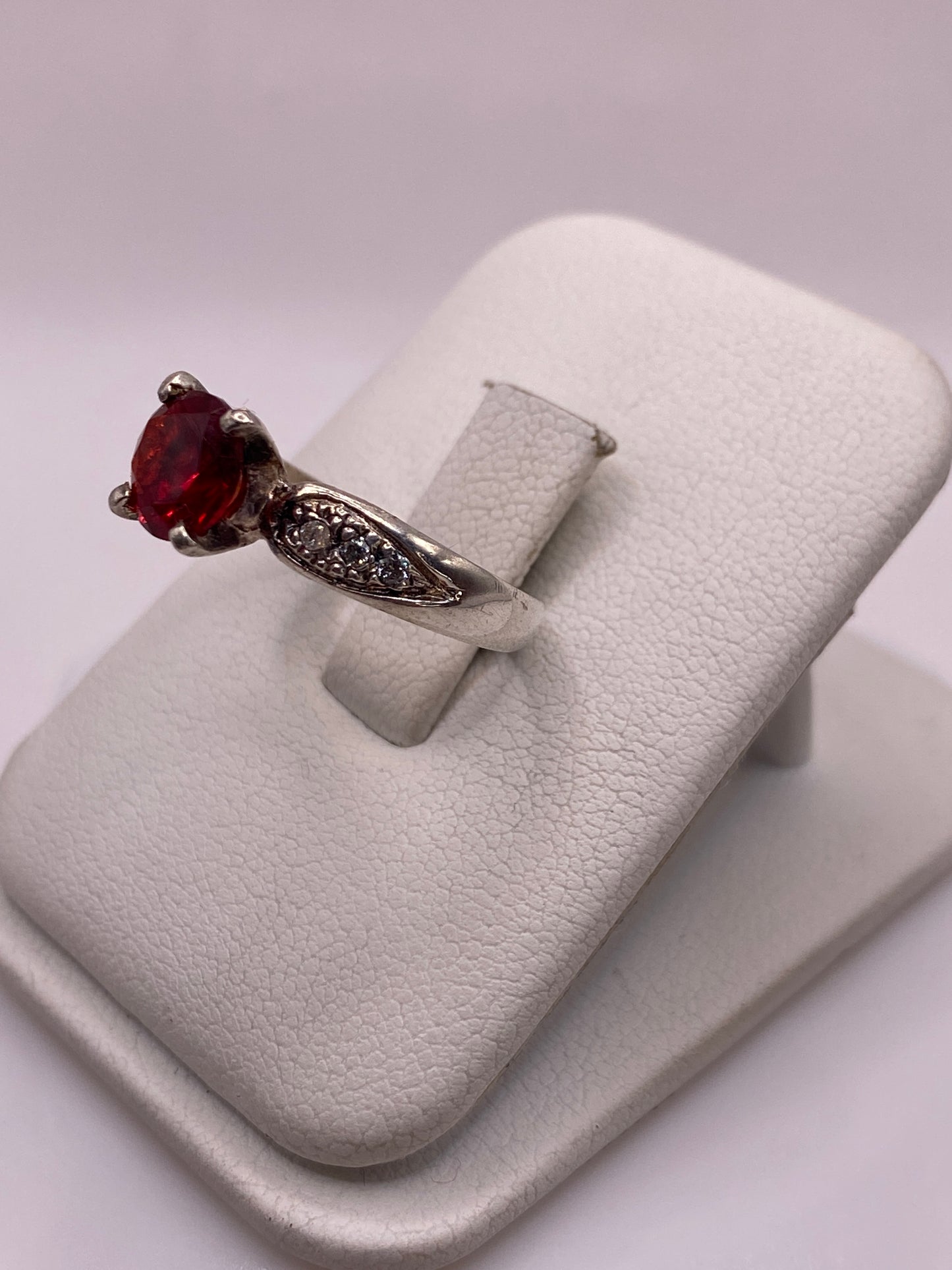 Vista lateral del anillo solitario de plata .925 con piedra roja engastada