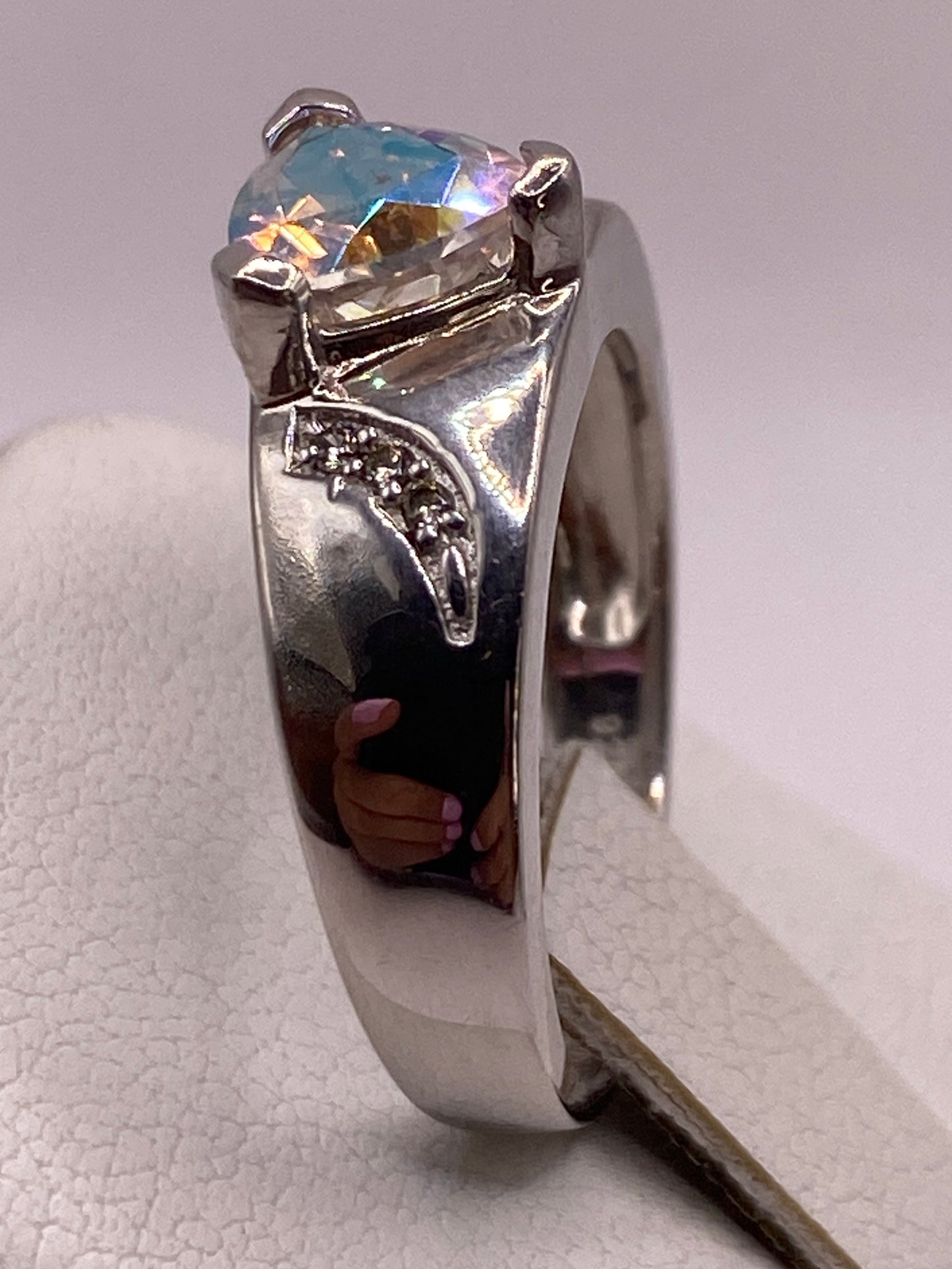 Detalle lateral del anillo en la mano, destacando la banda texturizada y el engaste en plata