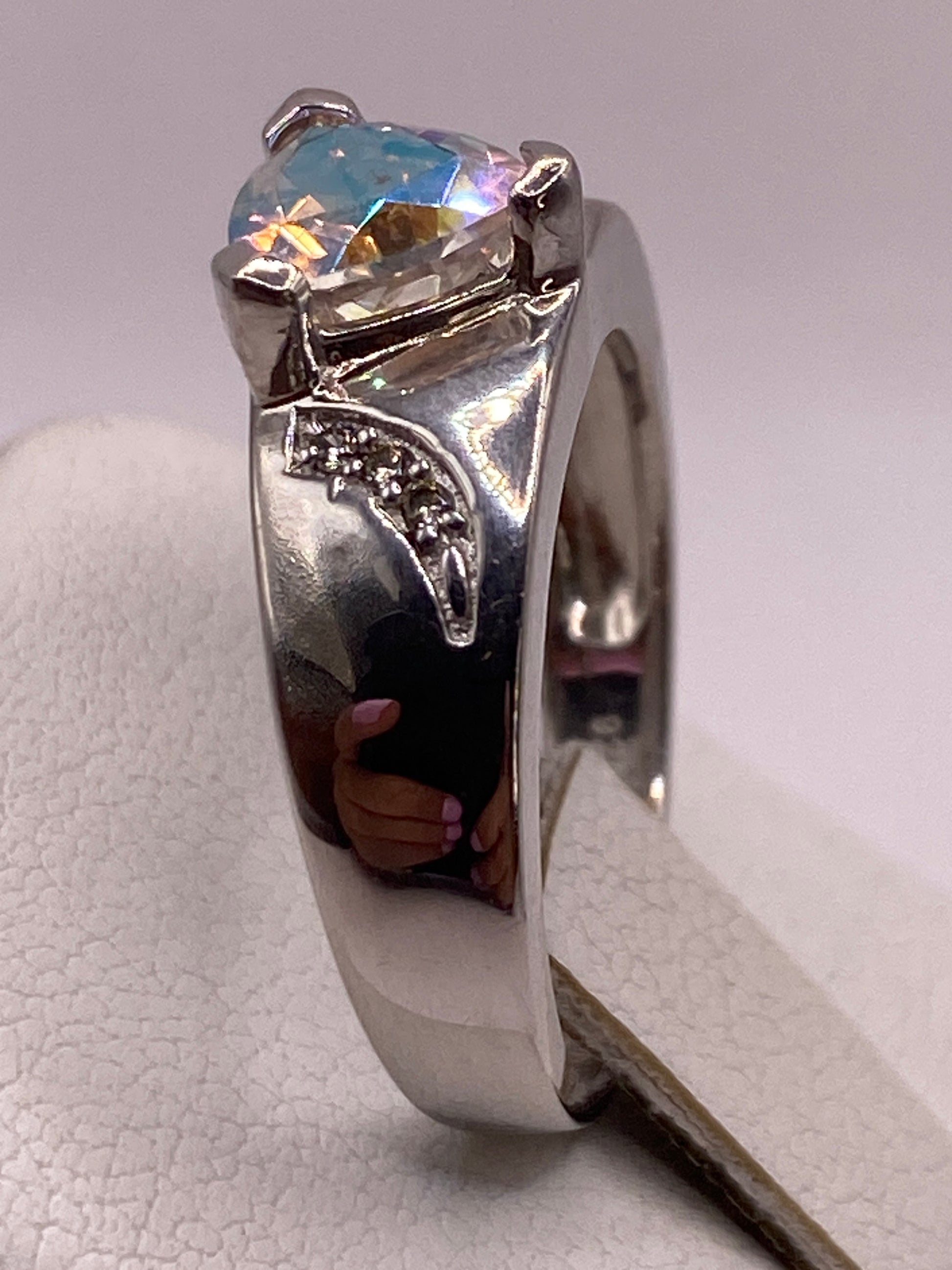 Detalle lateral del anillo en la mano, destacando la banda texturizada y el engaste en plata