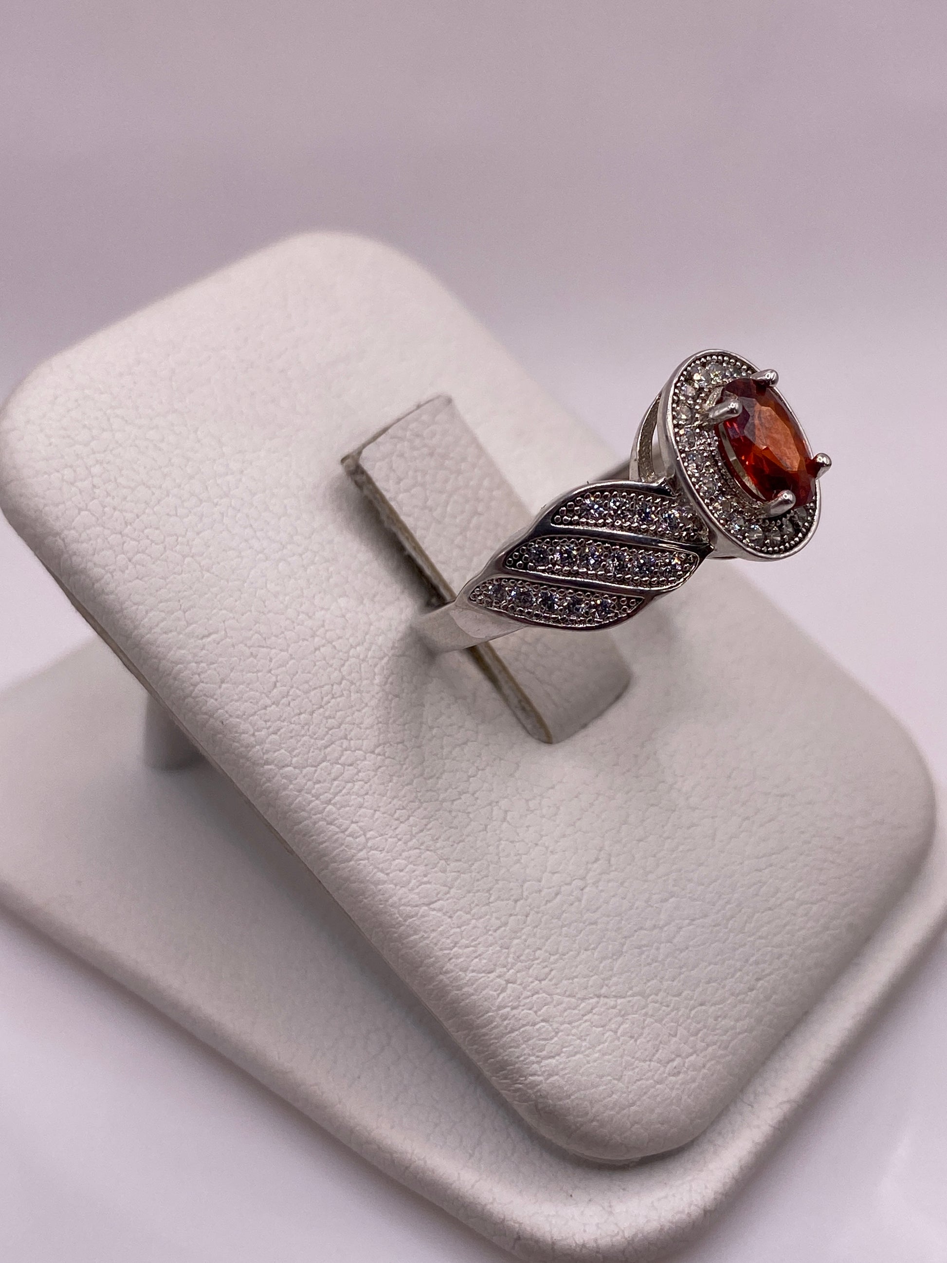 Anillo solitario plata .925 con piedra naranja, vista lateral mostrando el perfil de las alas
