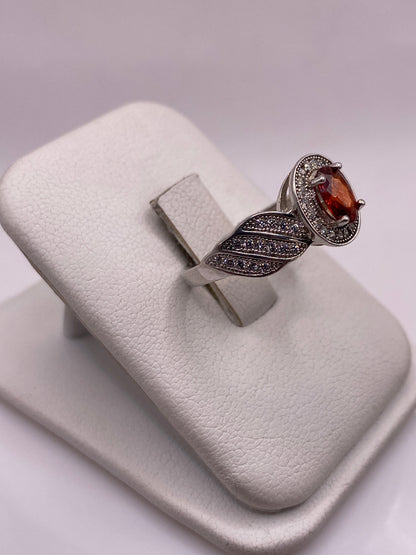 Anillo solitario plata .925 con piedra naranja, vista lateral mostrando el perfil de las alas