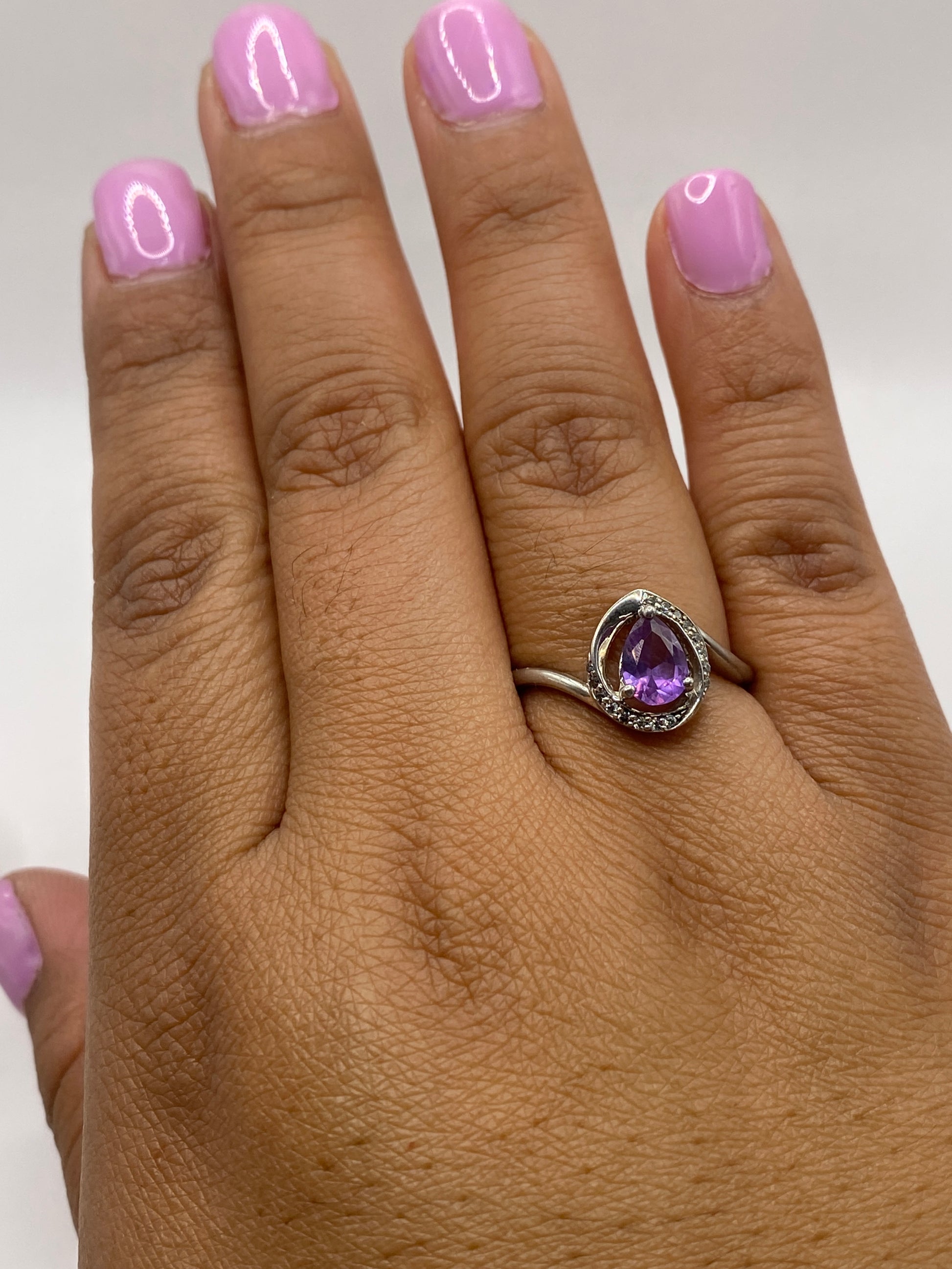 Anillo de plata morada sobre dedo, con circonia que refleja luz natural