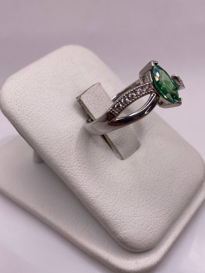 Vista frontal del anillo de circonia verde con diseño serpentino en plata .925