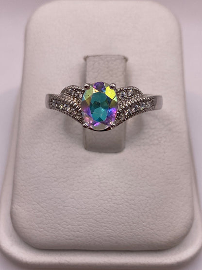 Anillo de plata con circonia multicolor en amarillo, azul y púrpura sobre almohada blanca