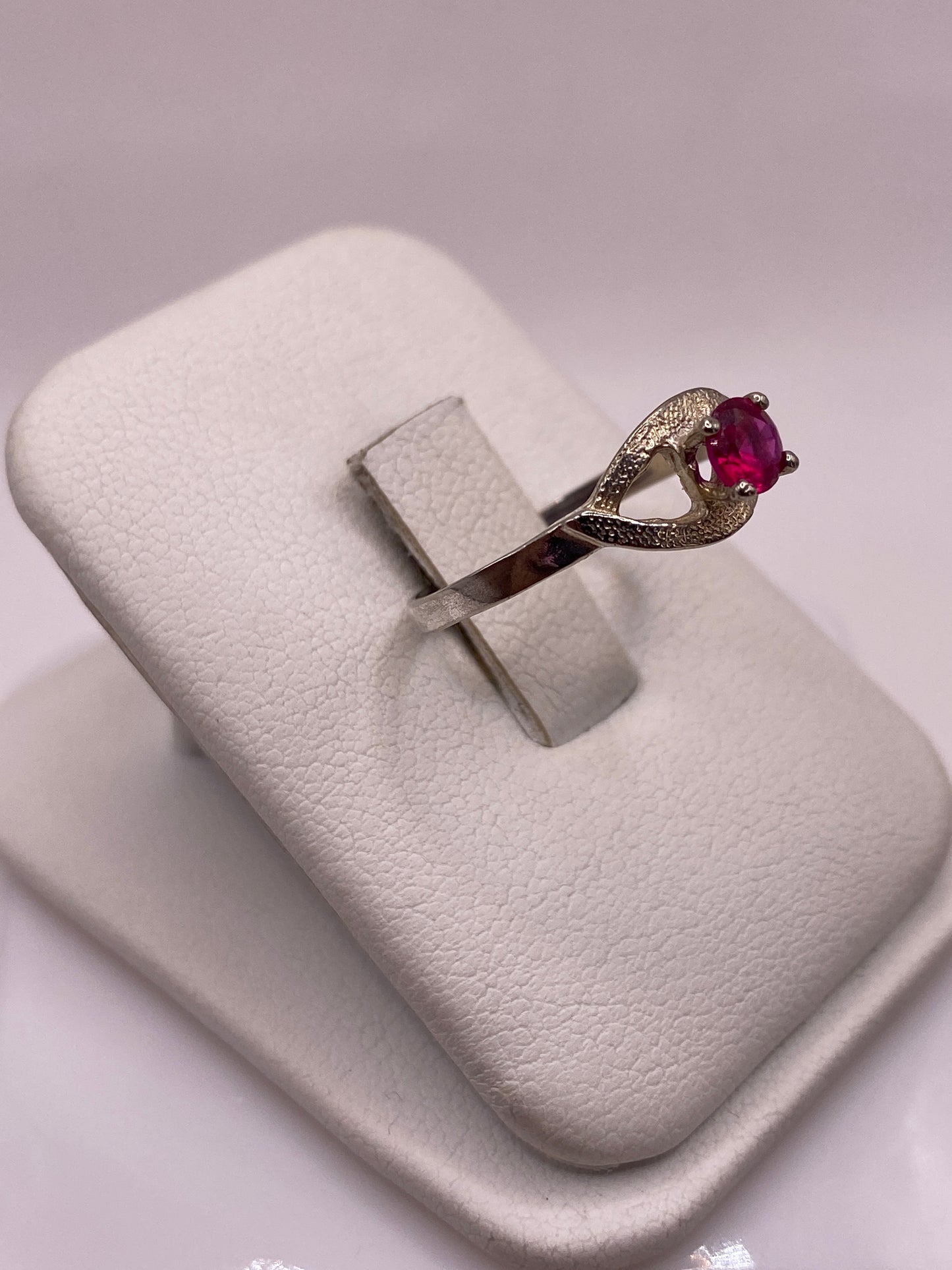 Detalle lateral del anillo mostrando la talla brillante de la circonia roja en plata .925