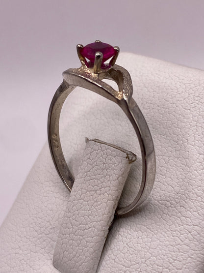 Anillo de circonia roja colocado en dedo, mostrando el brillo intenso de la piedra